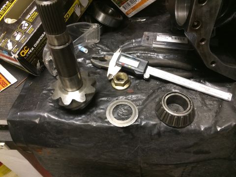 1996 Ford Bronco - Various automotive differential components are laid out on a black surface, with a digital caliper present.