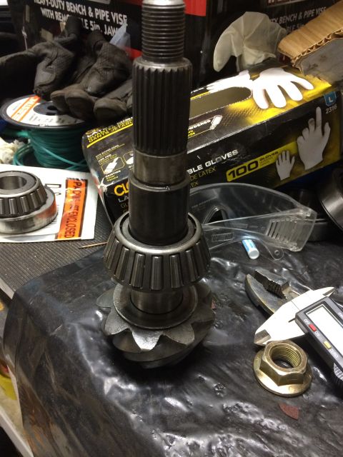 1996 Ford Bronco - Differential gear and pinion assembly, likely for a D44 axle, shown with a bearing and digital caliper for measurement.