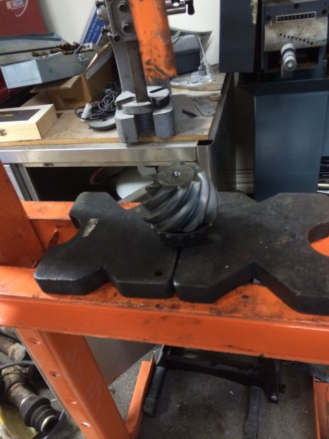1996 Ford Bronco - A close-up view of a differential gear resting on a black metal fixture.