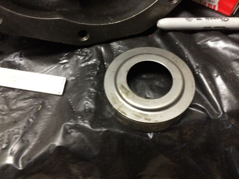1996 Ford Bronco - Close-up of a metal bearing race and housing part, with a marker nearby.