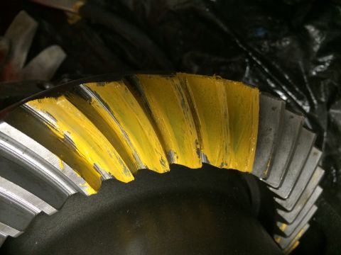 1996 Ford Bronco - A differential gear with yellow marking compound applied to its teeth is shown in a close-up view.