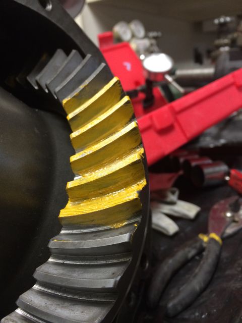 1996 Ford Bronco - Close-up of a differential gear showing yellow markings on its teeth, with tools and a red toolbox in the background.