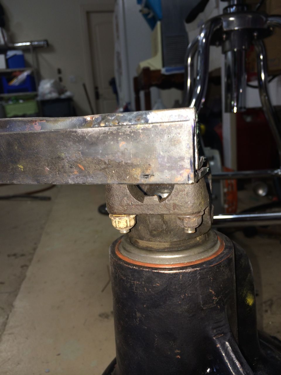Close-up of a metal part with bolts and a black cylindrical base