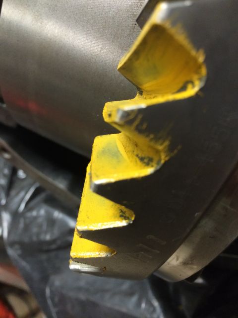 1996 Ford Bronco - A close-up view of a gear, possibly from a vehicle's drivetrain, with yellow paint applied to its teeth.