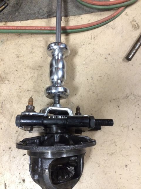 1996 Ford Bronco - A differential gear assembly is shown with a puller tool attached, resting on a workshop floor.
