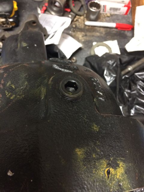 1996 Ford Bronco - This is a close-up view of a vehicle's differential cover, showing a hex plug and some yellow markings.