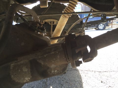 1996 Ford Bronco - The photo shows the underside of a vehicle, focusing on the rear axle and suspension system, with another truck in the background.