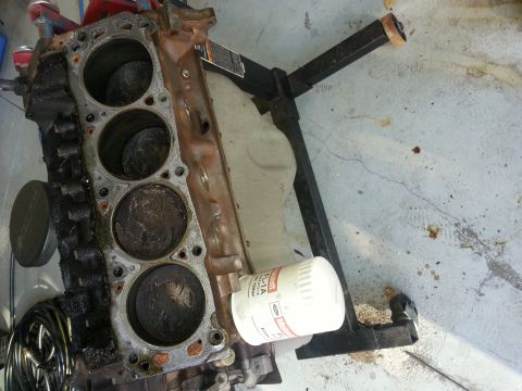 1994 Ford Bronco - Engine block on a stand with a Ford oil filter, showing internal cylinder damage.