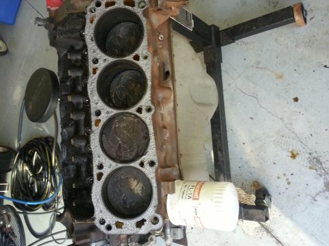1994 Ford Bronco - Engine block with pistons and oil filter, likely undergoing repair or rebuild.