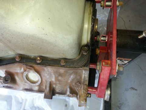 1994 Ford Bronco - Close-up of an engine block and oil pan, attached to a red engine hoist mount.