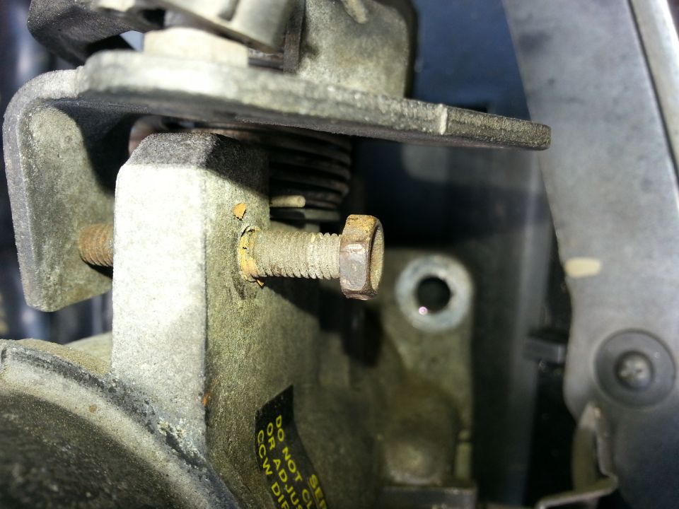 Close-up of a throttle body with a bolt and spring visible. Text on a sticker reads 'DO NOT SE... OR ADJUST CCW DIR'
