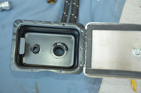 1979 Ford Bronco - A close-up view of an open metal container with a rubber seal and visible hardware.