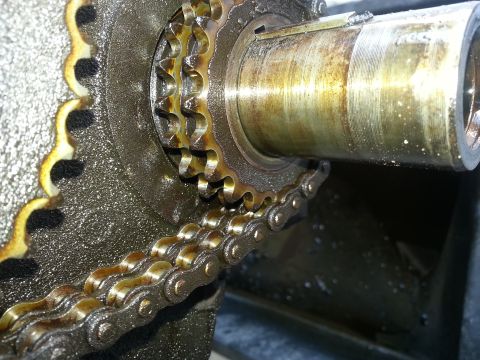 1994 Ford Bronco - Close-up of an oily engine timing chain and sprockets, showing mechanical components.