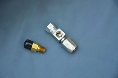 1979 Ford Bronco - Two metal fittings are shown against a plain background. One fitting has a black cap.