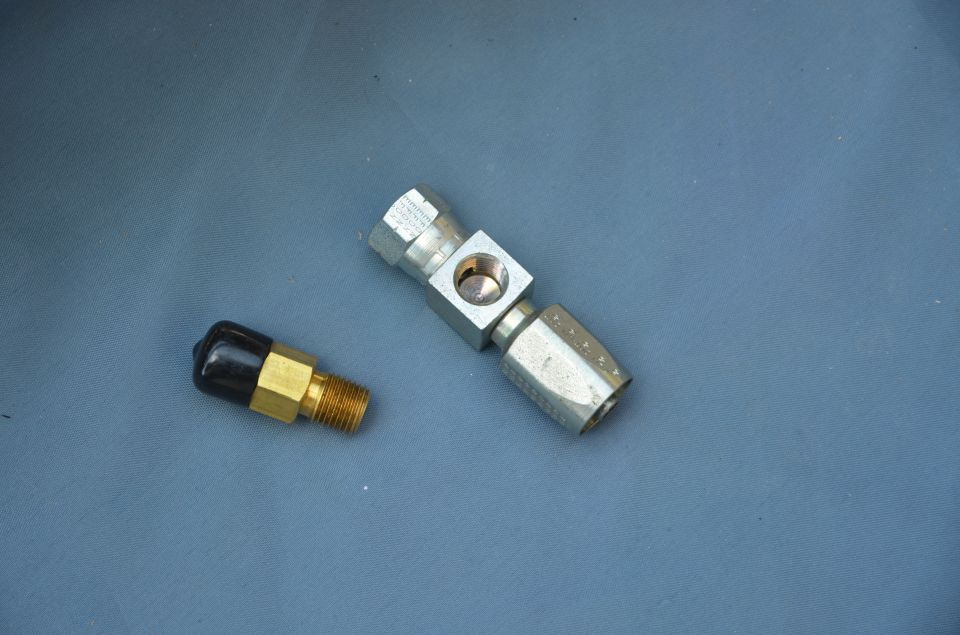 two metal fittings, one with a black cap