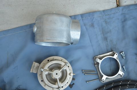 1979 Ford Bronco - Close-up of disassembled carburetor components, including an aluminum body, diaphragm, and mounting plate, laid out on a blue cloth.