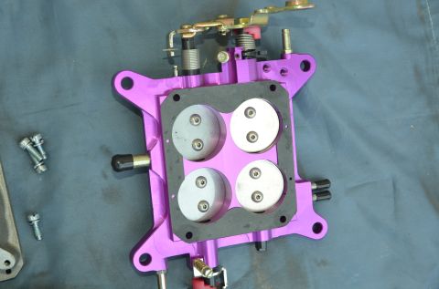 1979 Ford Bronco - Close-up of a purple carburetor, a component of a vehicle's fuel system.