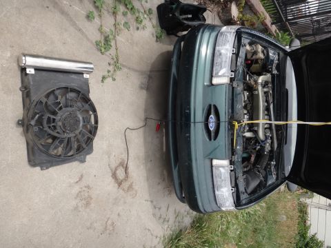 1995 Ford Taurus - The front of a green 1995 Ford Taurus is shown with its hood open and the radiator fan removed.