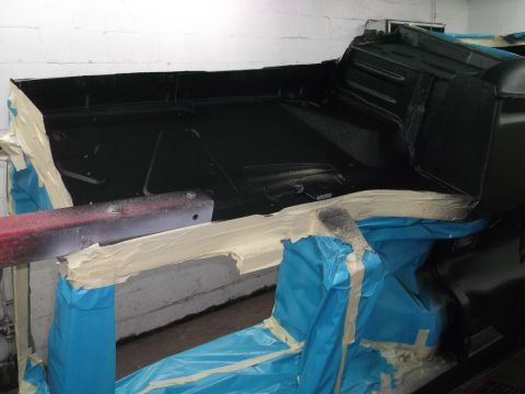 1967 Ford Mustang - The interior of a vehicle is masked and prepped for a new coat of paint, showing the careful preparation involved in restoration.