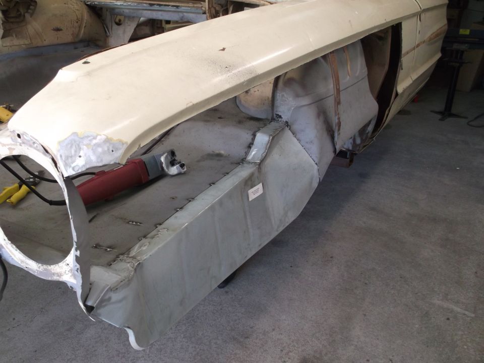 1964 Ford Galaxie fender and inner structure during repair, showing metalwork and a grinder