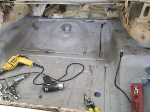 1964 Ford Galaxie - Tools are laid out in the empty trunk of a car, ready for work.