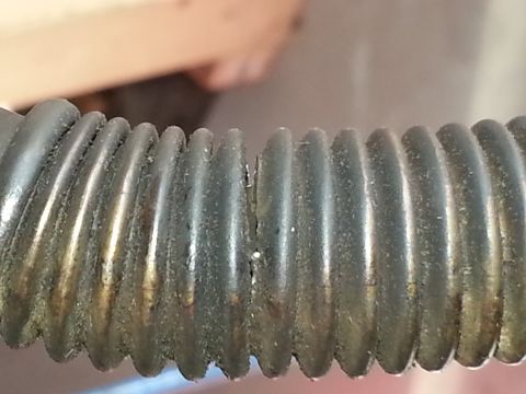 1994 Ford Bronco - A close-up view shows a damaged corrugated hose, likely a part from a vehicle.