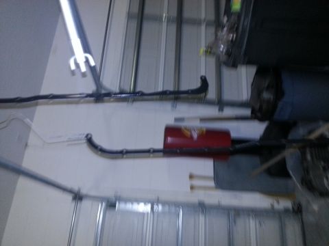 1994 Ford Bronco - Close-up of a vehicle's exhaust system, showing a red muffler and pipe.