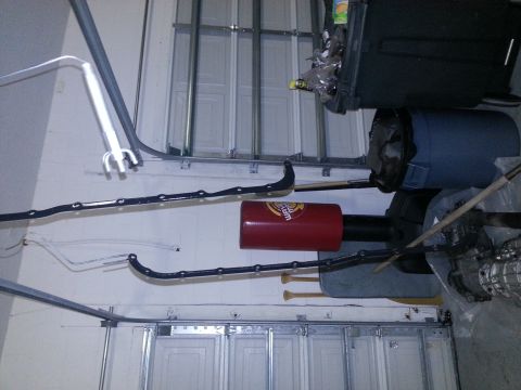 1994 Ford Bronco - Various automotive parts and storage items are visible in a garage setting, with a SuperMotors logo in the corner.