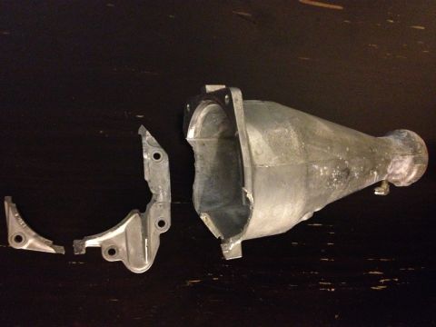 1992 Ford Crown Victoria - A damaged metal exhaust component lies in pieces on a dark, reflective surface.