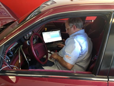 1992 Ford Crown Victoria - Man tunes a 1992 Ford Crown Victoria using a laptop connected to the car's diagnostics.