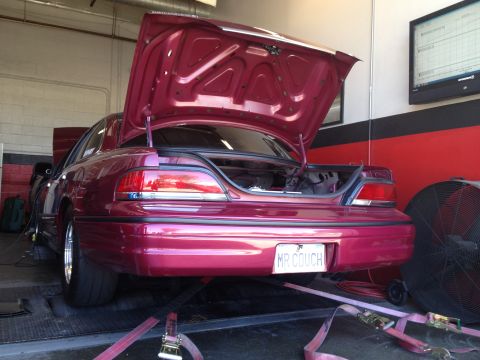 1992 Ford Crown Victoria - Rear view of a 1992 Ford Crown Victoria on a dynamometer, trunk open, with a custom license plate.