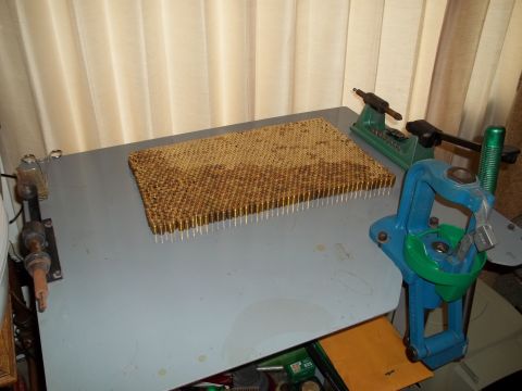 1972 Ford Ranchero - A workbench is set up for reloading ammunition with a press and a tray filled with cartridges.