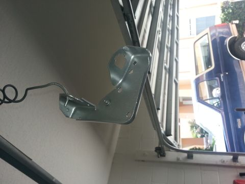 1994 Ford Bronco - A metal bracket is mounted on a wall, with a blue truck partially visible through an open garage door.
