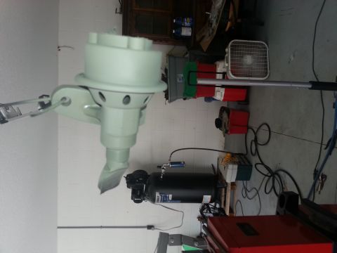 1994 Ford Bronco - A light green outboard motor part is shown mounted on a bracket, with an air compressor and other garage items in the background.