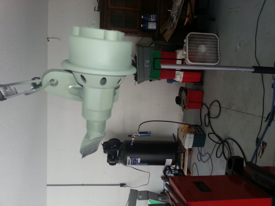 Light green outboard motor part with metal bracket and hose