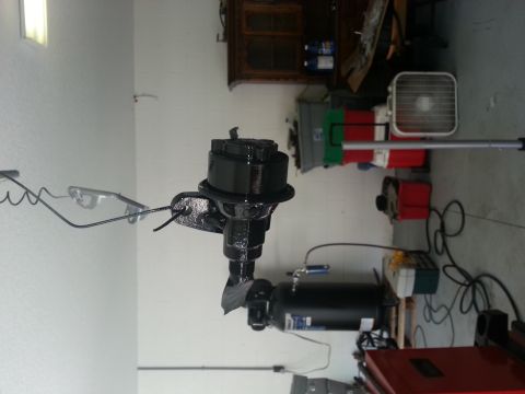 1994 Ford Bronco - A black vacuum booster part is shown in a garage setting with tools and equipment in the background.
