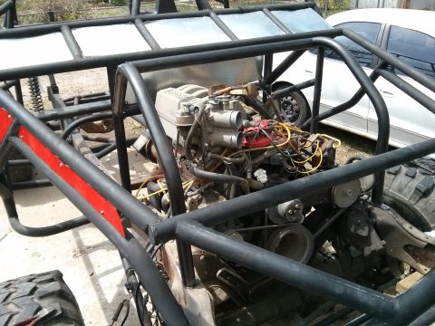 1986 Ford Bronco - Custom off-road buggy engine compartment showing the V8 engine and surrounding roll cage.