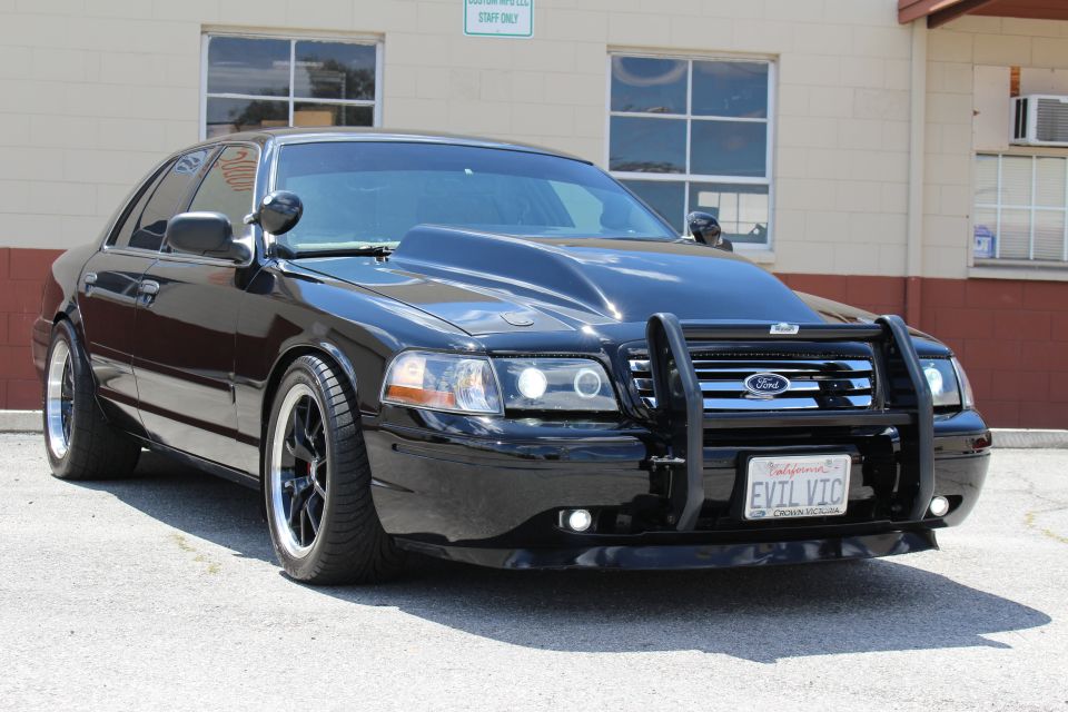Front of a black Ford Crown Victoria with light-bar push guard and EVIL VIC plate