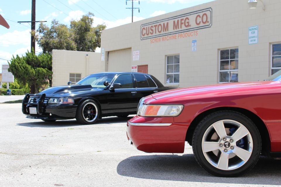 Red sedan front fender and headlight with black sedan beside Custom Mfg Co