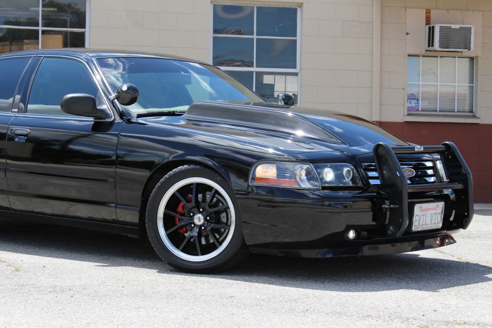 Close front three-quarter of black Crown Victoria with EVIL VIC license plate