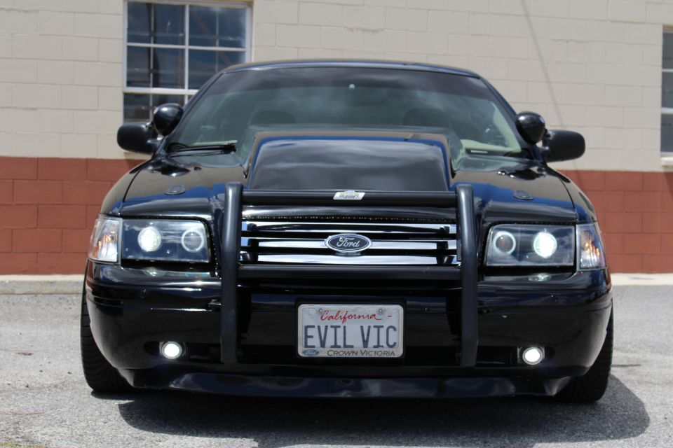Front close-up of a black Ford Crown Victoria with brush guard and California EVIL VIC plate