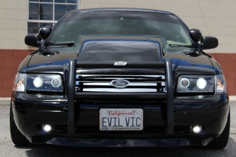 2003 Ford Crown Victoria - lowered black Ford Crown Victoria with a brush guard and halo projector headlights, shown from the front.