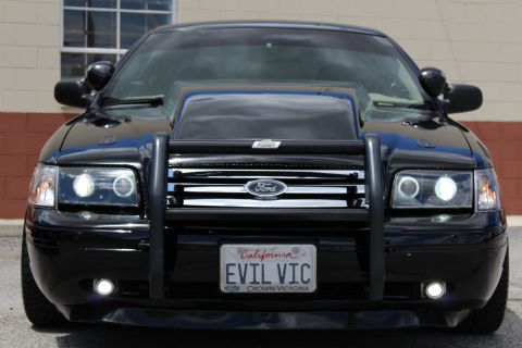 2003 Ford Crown Victoria - Front view of a black Ford Crown Victoria with a chrome-trimmed grille, brush guard and California 'EVIL VIC' plate.