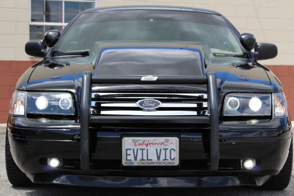 Close front shot of a black Ford Crown Victoria showing Ford badge and California EVIL VIC plate