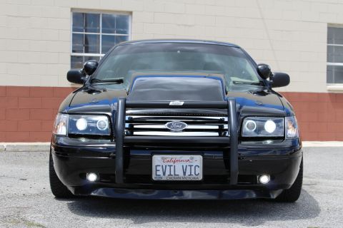 2003 Ford Crown Victoria - black Ford Crown Victoria with a brush guard and projector headlights, photographed from directly in front.