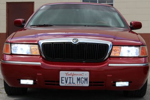 2003 Ford Crown Victoria - close front view of a maroon Mercury sedan with a chrome grille, Mercury emblem and California 'EVIL MGM' plate.