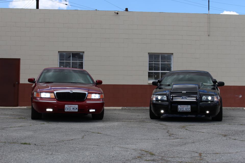 Close front view of maroon Mercury with EVIL MOM plate and black Ford