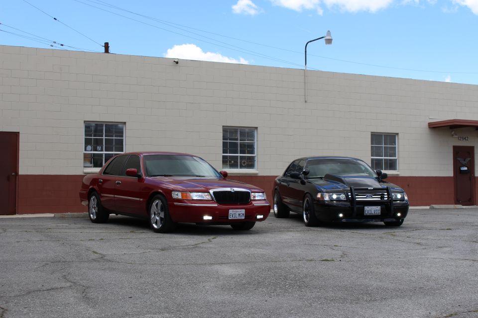 Maroon Mercury and black Ford sedan parked at three-quarter angle