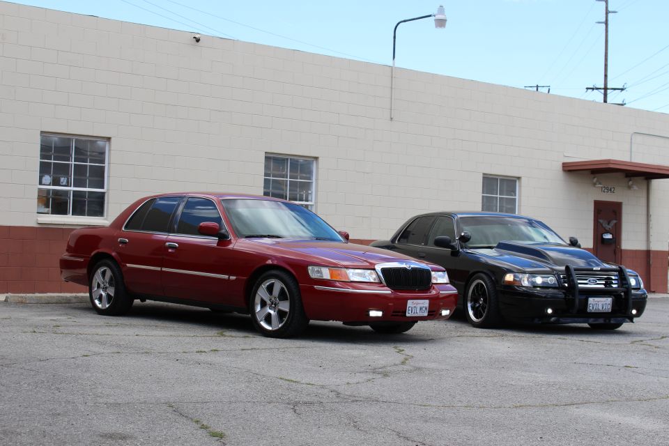 Front-side view of maroon Mercury and black Ford on chrome wheels
