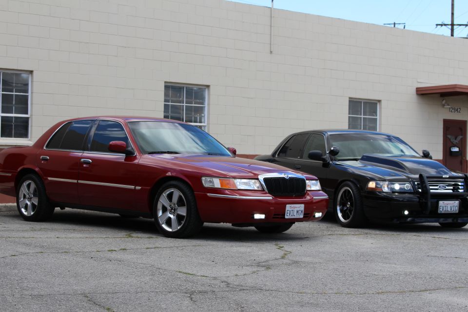 Maroon Mercury EVIL MOM and black Ford EVIL VIC parked front-side